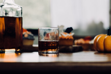 a glass of whiskey on wood bar, soft focus.	