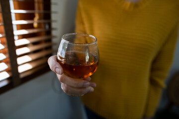 hands holding glass of whiskey.