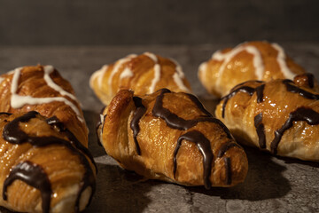 Set of delicious freshly baked croissants with chocolate on top on a background