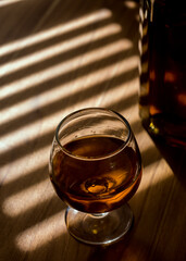 glass of whiskey on wood table.	