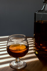 a glass of whiskey on wood bar, soft focus.	
