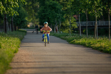 Obraz premium Boy learning to ride bike. Child travels through urban alley