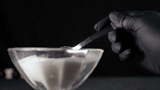 White sugar in a spoon in a sugar bowl close up