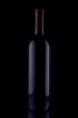 glass bottle of red wine on black background