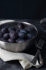 dramatic autumn still life with plums on a dark background. Rustic