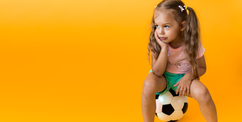 Authentic cute smiling preschool little girl with classic black and white soccer ball look at...