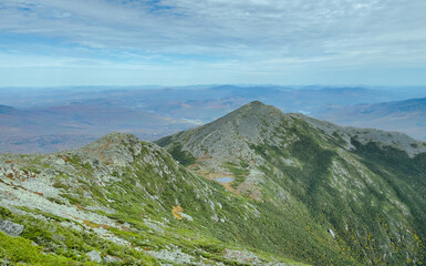 Large, rocky mountains in the sky above a dense and lush forest. These are mountains in the...