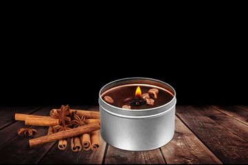 Burning aroma candle and cinnamon sticks
