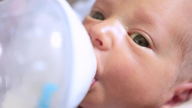 newborn drinks milk from a bottle. happy family artificial nutrition milk powder kid dream concept. lifestyle newborn close-up eating. newborn baby drinking milk from a bottle