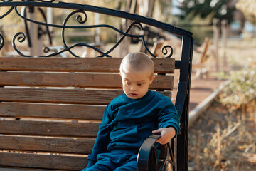 Cute blond boy with down syndrome walks in the park