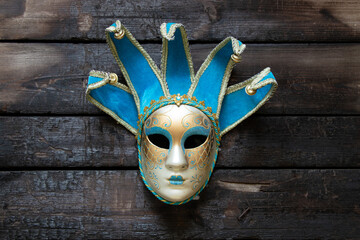 Venetian mask lies on a wooden table ,theatrical mask