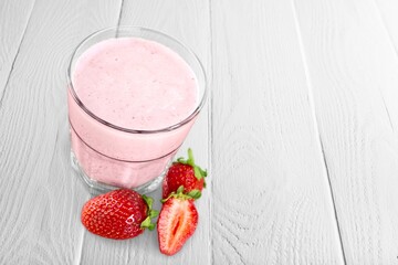 Tasty sweet milk smoothie with strawberry on the table