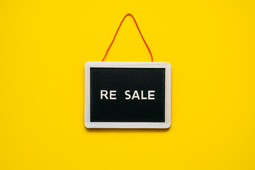 Resale-commerce, re-commerce, re sale concept. Buyback, Trade-In, and Upcycling in Retail. Circular economy. Word resale and clothing on yellow background - obrazy, fototapety, plakaty
