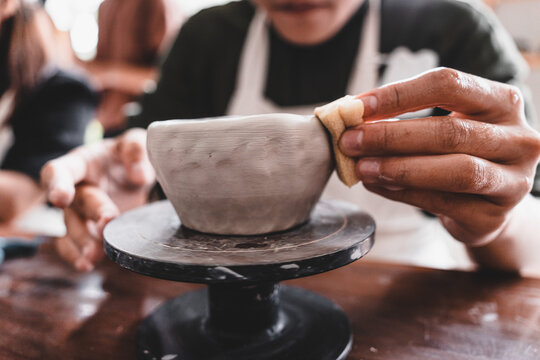 View of male hands works with clay makes future ceramic plate, ceramic artist makes classes of hand building in modern pottery workshop, creative people handcrafted design