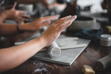 View of female hands works with clay makes future ceramic plate, ceramic artist makes classes of hand building in modern pottery workshop, creative people handcrafted design