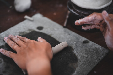 View of male hands works with clay makes future ceramic plate, ceramic artist makes classes of hand building in modern pottery workshop, creative people handcrafted design