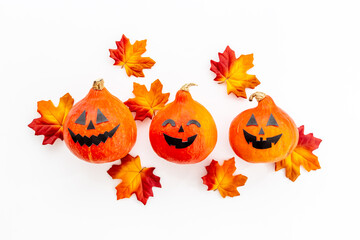 Halloween holiday background with pumpkin head and dry leaves, top view
