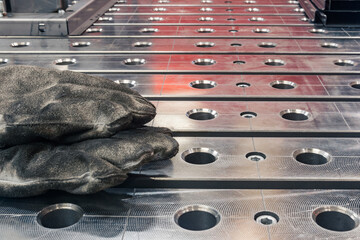 oiled burnt work gloves of a welder left on the welding table close-up