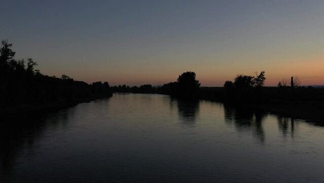 Slow horizontal pan over Williamette River to shore, at dusk, summer