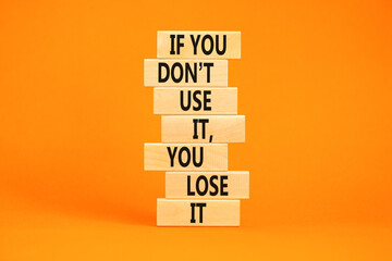 Use or lose symbol. Concept words If you do not use it you lose it on wooden blocks on a beautiful orange table orange background. Business motivational and use or lose concept.