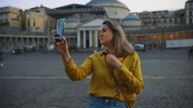 Woman doing selfie at Piazza del Plebiscito in Naples, Italy.