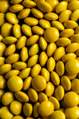 Yellow candy coated chocolate button sprinkle texture - M&Ms, Smarties, sprinkles