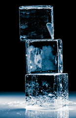 Pyramid of natural crystal clear ice cubes on black background. Stacked textured transparent...