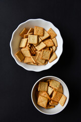 Delicious peppery cookies in a white plate on a black background.