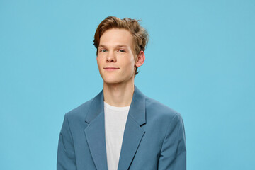 portrait of a young guy in a jacket on a blue background
