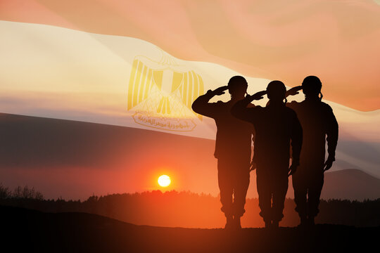 Double exposure of silhouettes of a soliders and the sunset or the sunrise against flag of Egypt. Greeting card for Independence day, Memorial Day, Armed forces day, Sinai Liberation Day.