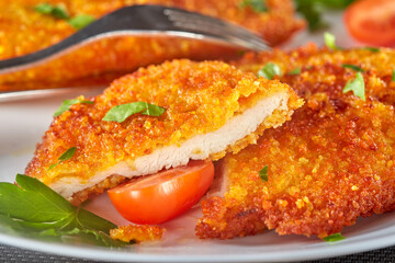 Fresh breaded chicken schnitzel with cherry tomatoes and herbs