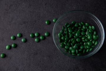 Green candy coated chocolate button sprinkles in a bowl on dark slate - M&Ms, Smarties, sprinkles