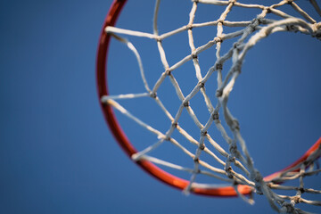 closeup of basketball basket net of white rope view from underneath against a blue sky