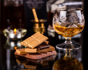 glass of cognac with broken chocolate bars