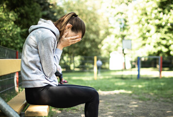 sad female sitting on bench