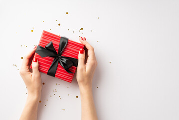 Black friday shopping concept. First person top view photo of girl's hands holding red giftbox with...