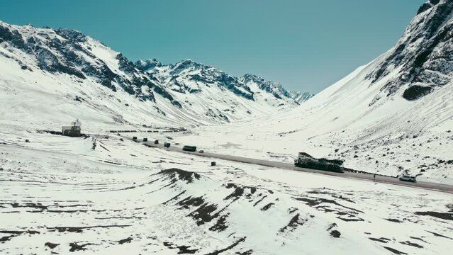 Aerial shot of a Road in the mountains with trucks in Los Andes. Near the border between Argentina and Chile.