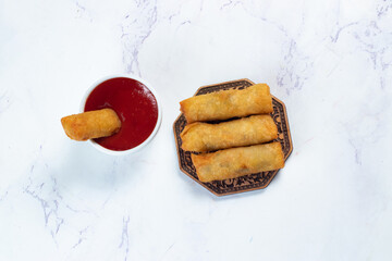 Deep fried spring roll with tomato sauce and mayo dip served in dish isolated on table top view of fastfood