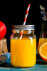 Fresh orange juice in a glass jar with a straw. Healthy fruits and juices