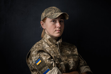 Portrait of beautiful girl with yellow and blue ukrainian flag on her cheek wearing military...