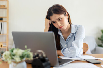 Female freelance is feeling stressful and headache from thinking the strategy plan of the business