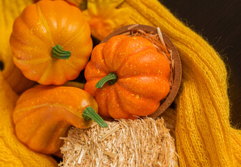 Autumn background with knitted sweater, pumpkin, briquette hay. Hello October, November. Autumn season.