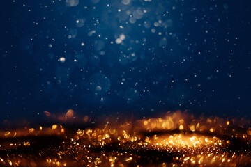 Glowing in the dark defocused golden glitter texture. Christmas and winter holidays background
