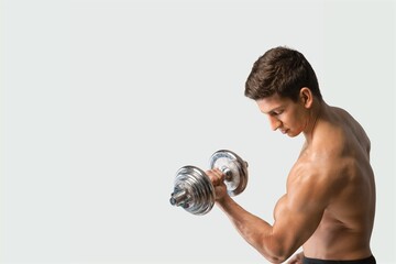 Handsome young man exercising with dumbbells