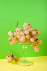 a bunch of green grapes on a pedestal, on a green background