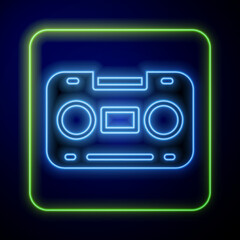 Glowing neon Retro audio cassette tape icon isolated on blue background. Vector