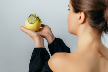 young woman holding a ripe quince fruit in her palm. High quality photo