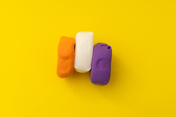 Children's bright plasticine lies on a yellow background