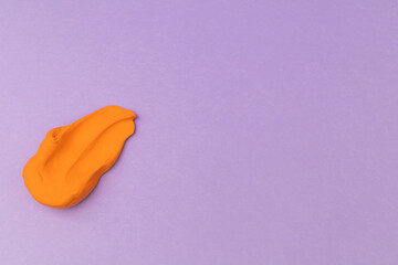 Children's bright plasticine lies on a purple background