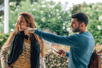 autumn travel couple looking for direction or pointing